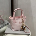 Roze mini crossbody emmertas met reliëf, pluche bedeltje en verstelbare riem - Met Hanger / Roze