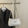 White faux crocodile leather shoulder bag with a silver metal bow buckle on a suit hanger - White