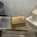 Mini borsa quadrata dorata con chiusura a fiocco in metallo e tracolla a catena chic - Oro