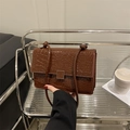 Dunkelbraune Schultertasche mit Krokodilprägung, glänzender Lackoberfläche und Metallschloss - Braun