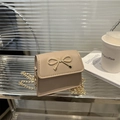 Elegant beige mini square bag with golden bow hardware and delicate chain strap - Khaki