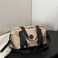 Große beige Reisetasche mit schwarzen Riemen und Logo-Detail in minimalistischem Design - Khaki