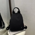 Minimalistischer schwarzer Damenrucksack aus Nylon mit runder Metallschnalle und Logo - Schwarz