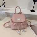 Mini mochila rosa de cuero PU con insignia metálica y cuentas sobre fondo minimalista - Rosa