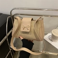 Minimalist beige crossbody square bag with gold bow clasp and sleek leather texture - Khaki