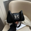 Minimalist black faux leather shoulder bag with a silver metal bow accent and flap cover - Black