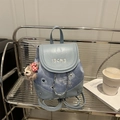 Light blue denim backpack with IBCMB embroidery and plush bear pendant on metal shelf - With Ornament / Blue