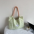 Green and white checkered canvas tote bag with orange rope handles and laptop prop - Green