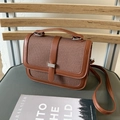 Detailansicht einer braunen Canvas-Handtasche mit Lederbesatz und silbernem Metallakzent - Braun