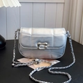 Chic silver quilted crossbody bag with metal chain strap on a minimalist desk setting - Silver