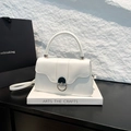 Bolso chic de cuero blanco con cierre de metal plateado en un soporte de exhibición de arte - Blanco
