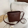 Bolso saco minimalista en cuero marrón oscuro con correa ajustable y hebilla decorativa - Marrón