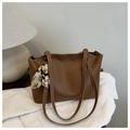 Dettaglio della borsa tote in pelle marrone con cuciture a contrasto e sciarpa di seta decorativa - Cuoio