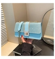 Close-up of light blue chain bag with sparkling glitter flap and gold metal lock - Blue