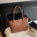 Close-up of caramel brown woven texture and intricate leather pattern on large tote bag - Brown