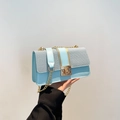 Light blue crossbody bag featuring woven texture, gold square lock, and metal chain strap - Blue