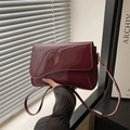 Elegante borsa a tracolla in vernice bordeaux con patta irregolare e lucida - Rosso