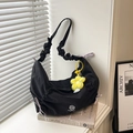 Borsa a mezzaluna in nylon nero con tracolla arricciata, fiocco viola e ciondolo a fiore - Con Ciondolo / Nero