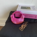 Detailansicht der pinkfarbenen Halbmond-Handtasche mit strahlender Textur und Kette - Rosa