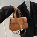 Elegante braune gewebte Handtasche mit goldenem Drehverschluss und vielseitigem Schultergurt - Braun