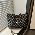 Bolso tote de cuadros con flecos y colgante de estrella bajo luz natural de ventana - Celosía Negra