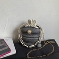 Detail of woven straw bucket bag with large pearl accent and stylish dual chain strap - Black