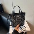 Borsa a secchiello intrecciata nera e grigia con motivi geometrici e manici in pelle - Nero