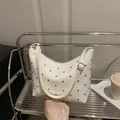 Retro white bucket bag with silver studs and adjustable strap on a metal stand - White