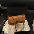 Elegant camel brown underarm bag with gold twist lock on soft white fabric texture - Brown