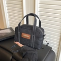 Chic black denim handbag with contrast stitching and leather patch on white backdrop - Black