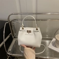 Sac seau blanc à texture litchi avec fermoir doré tenu à la main au décor chic - Blanc