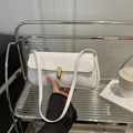 White crocodile pattern baguette bag with a gold oval twist lock and shoulder strap - White