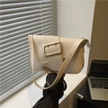 Minimalist cream white shoulder baguette bag with large gold buckle in hand - White