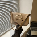 Chic beige leather shoulder bag with a large gold buckle in a minimalist office setting - Khaki