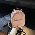 Mini mochila rosa chic con ribete plateado y letras negras sobre escritorio negro - Rosa