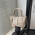 Bolso tipo cubo beige con cierre giratorio dorado y correa de hombro ajustable - Beige