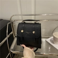 Sac à dos noir à texture tissée avec boucle métallique dorée sur une étagère - Noir