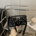 Bolso de hombro punk negro Y2K con remaches plateados y ojales en un estante - Negro