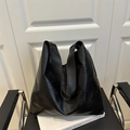 Grand sac cabas noir en cuir PU avec large bandoulière posé sur une chaise d'intérieur - Noir