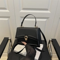 Elegante bolso acolchado negro con cierre de doble anillo dorado y asa superior - Negro