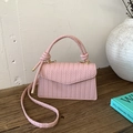 Detail of pink woven texture crossbody bag with gold hardware and knotted top handle - Pink