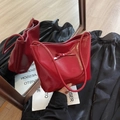 Rote glänzende Schultertasche mit Schleife auf stilvollem reflektierendem Hintergrund - Rot