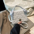 White quilted crossbody bag with golden hardware and decorative silk scarf handle - White