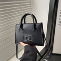 Borsa a tracolla nera minimalista con logo G goffrato e doppi manici cilindrici - Nero
