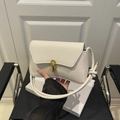 Minimalist cream white crossbody bag with golden oval lock and knotted strap detail - White