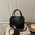 Black snake-embossed crossbody bag with cylindrical top handles and fashion text detail - Black