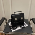 Mini sac à dos noir brillant avec étoiles argentées sur une chaise moderne - Noir
