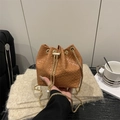 Bolso cubo trenzado marrón con cadena dorada mostrado en un ambiente cálido y acogedor - Marrón