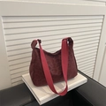 Burgundy crossbody bag with leopard print and wide red strap on white books - Red