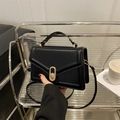 Schicke schwarze Lederumhängetasche mit elegantem goldenem Drehverschluss aus Metall - Schwarz